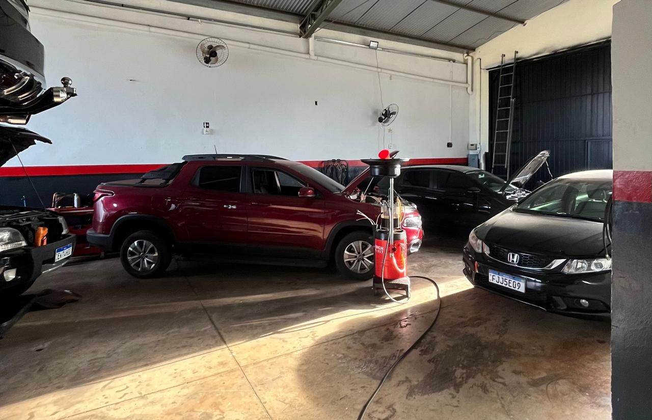 Interior da oficina JL Mecânica com carros em manutenção